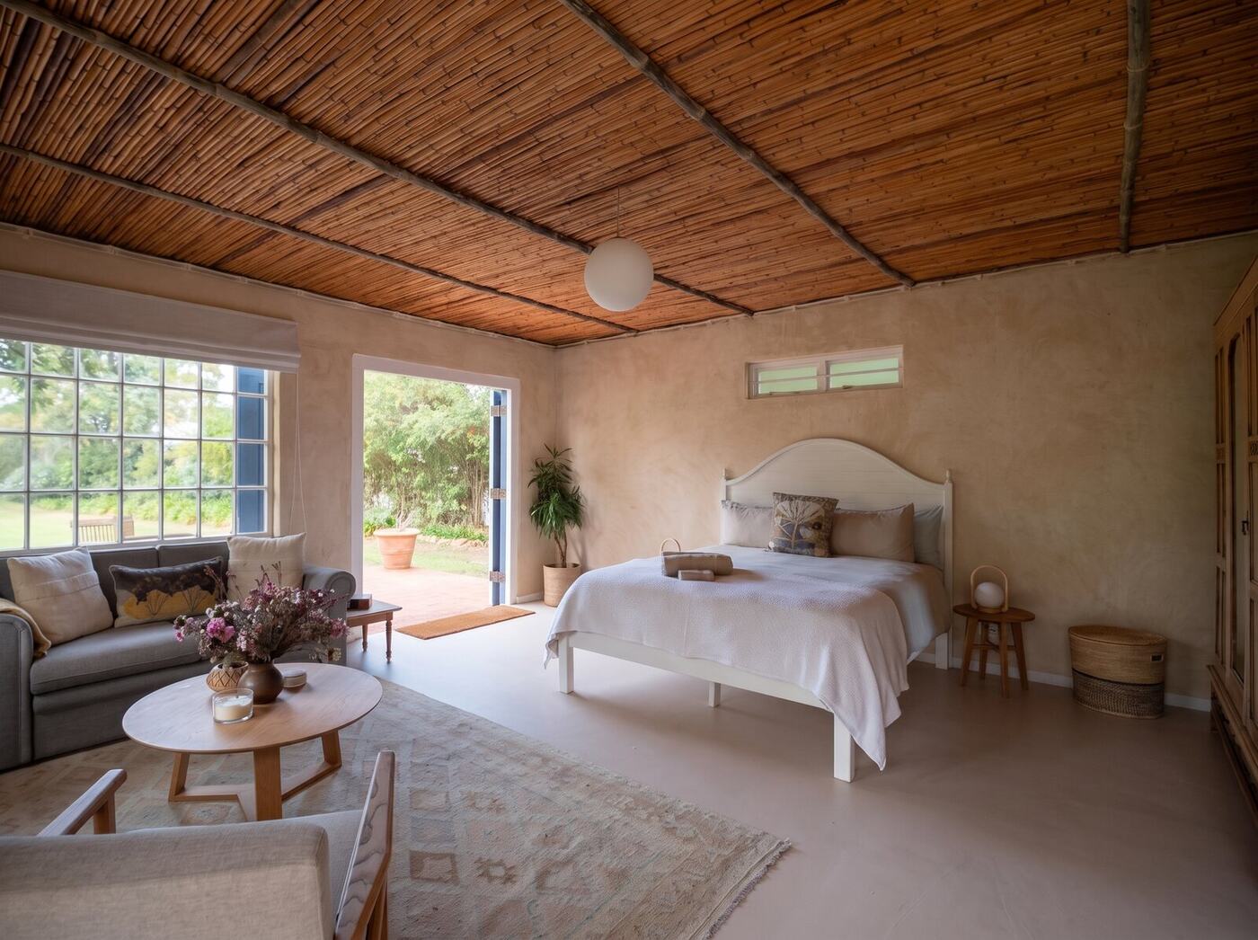 The room opening onto the garden: sofa, flowers, bed