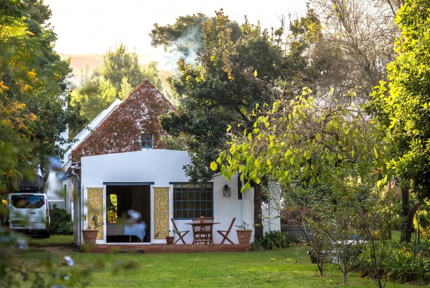 Chimney smoke rising from the cottage, lawn in the foreground